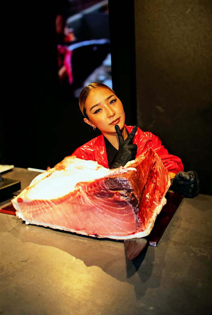 A member of the team behind a large block of bluefin tuna belly